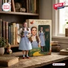 The Wizard of Oz 87th Anniversary Figure of Dorothy holding Toto, standing beside her collectible display box on a desk.