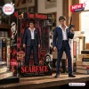 Tony Montana collectible figure by Hot Toys displayed next to its branded retail packaging box on a wooden desk.