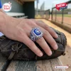 Close-up of a Toronto Blue Jays 50th Anniversary Championship Ring worn on a hand resting over a baseball glove.