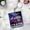 Square Transformers 40th Anniversary double sided keychain featuring a gradient graphic on a white wood tabletop background.