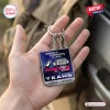 Hand holding a square Transformers 40th anniversary double sided keychain with 1986-2026 text.