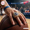 USA Basketball FIBA 2026 World Champions Ring featuring a large blue gemstone on a gold band held over a textured basketball.