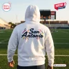 Back view of a white hoodie with San Antonio text standing on a football field.