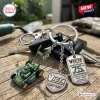 Closeup of Victa Mowers 75th Anniversary Metal Keychain resting on a wooden surface with charms.