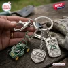 Closeup of Victa Mowers 75th Anniversary Metal Keychain held in hand over wooden surface.