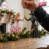 Wicked Glinda and Elphaba Christmas ornament showing Glinda in a pink dress and Elphaba in a black hat holding hands.