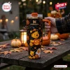 Hand holding a black Winnie the Pooh Halloween Pumpkin 40oz Stanley Tumbler with character designs on a wooden table.