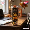 Front view of a Winnie the Pooh Halloween Pumpkin 40oz Stanley Tumbler featuring pumpkin and spiderweb graphics on a desk.