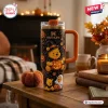 Front view of a Winnie the Pooh Halloween Pumpkin 40oz Stanley Tumbler featuring a witch hat design on a table.