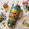 Front view of a Winnie the Pooh Hundred Acre Wood 40oz Stanley Tumbler featuring embossed woodland characters and gold accents.
