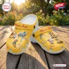 Outdoor view of Winnie the Pooh Yellow Clogs With Charms on a wooden deck.