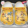 Top view of Winnie the Pooh yellow clogs with character charms.