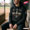 Man wearing a WPBL Los Angeles Queens 2026 Champions black pinstripe hoodie while sitting in a dugout.