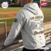 Back view of WPBL Los Angeles Queens 2026 Champions White Hoodie with pinstripes worn at a baseball field.