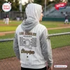 Back view of a person wearing the Los Angeles Queens 2026 champions white hoodie with player names at a baseball field.