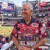 Older man wearing a red graphic Hawaiian shirt featuring the Yes, I'm Old But I Saw Atlanta Braves Greatness design at a stadium.