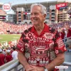Older man wearing Oklahoma Sooners Hawaiian shirt in a stadium.