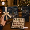 Hand holding a 2026 Heritage Christmas Ornament Advent Calendar box tied with a gold ribbon, featuring miniature ornaments inside.