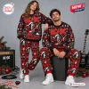 Front view of a couple wearing matching AC/DC High Voltage Christmas sweater and jogger sets.