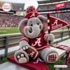 Front view of an Alabama Crimson Tide plush elephant toy holding a football and pennant in a stadium setting.