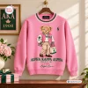 Front view of an Alpha Kappa Alpha Pink Bear Sweatshirt featuring a teddy bear graphic holding a green bag.