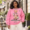 Front view of a woman wearing an Alpha Kappa Alpha pink bear sweatshirt.