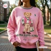 Front view of an Alpha Kappa Alpha pink bear sweatshirt featuring a teddy bear graphic in a varsity jacket.