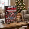 Front view of an Atlanta Falcons NFL Advent Calendar box with miniature figurines on a wooden table near a tree.