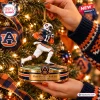 Close-up of a football player Christmas ornament hanging on a lit tree.