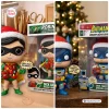 Side-by-side view of a Batman Holiday Lights Edition Vinyl Figure and companion figure in boxes.