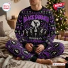 Front view of a person wearing a Black Sabbath Christmas ugly sweater and pants set featuring band members and purple winter motifs.