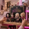 Four plush keychains in black and pink hanbok outfits standing in front of a collector box.