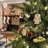 Hanging ornaments including a shopping bag, handbag, high heel, coat, and taxi on a Christmas tree for the Bloomingdale's New York Advent Calendar 2026.