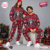 Man and woman modeling a Bon Jovi Christmas Sweater Jogger Set in a holiday decorated studio.