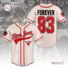 Front and back view of a cream baseball jersey with red trim, featuring text and numbers against a patterned background.