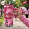Hand holding a pink Breast Cancer 41st Anniversary 1985-2026 Handle Tumbler outdoors.