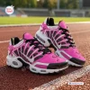 Side view of pink and white Breast Cancer Awareness Ribbon Air Max Plus Sneakers on a running track.