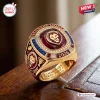 Closeup of Brisbane Lions AFL Champions 2024-2026 Three-Peat Ring on wood.