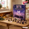 Front view of a BTS Advent Calendar Figurine Set displayed on a wooden desk with mini figures and string lights.