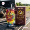 Front view of a tie dye Buc-ees 44th Anniversary Tumbler Cup with matching box on a truck bed.