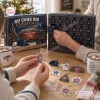 Hands opening a Chicago Cubs Christmas advent calendar with daily compartments and scattered baseball themed ornaments.