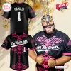 Man wearing Los White Sox Mexican Heritage baseball jersey with pink geometric patterns and mask.