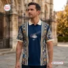 Front view of a man wearing a Christian Dior Premium Polo Shirt with blue and gold architectural motifs.