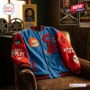 Front view of a blue and red Chucky Killer Doll Blue Varsity Jacket draped over a brown leather armchair.