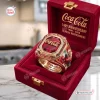 Closeup of a Coca-Cola 140th Anniversary 1886 - 2026 Ring inside a red velvet display box.