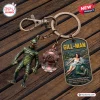 Top-down view of a Creature From The Black Lagoon Gill Man keychain with charms on wood.