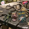 Closeup of Creature From The Black Lagoon Gill Man keychain charms resting on a weathered wooden surface.