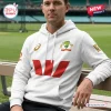 Man sitting on a bench wearing the Cricket Australia 150th Anniversary White Hoodie with sponsor logos.