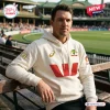 Man wearing the Cricket Australia 150th Anniversary White Hoodie while sitting on a wooden bench at a stadium.