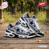 Side view of Dallas Cowboys AT&T Stadium Air Max Plus Sneakers resting on a wooden bridge.